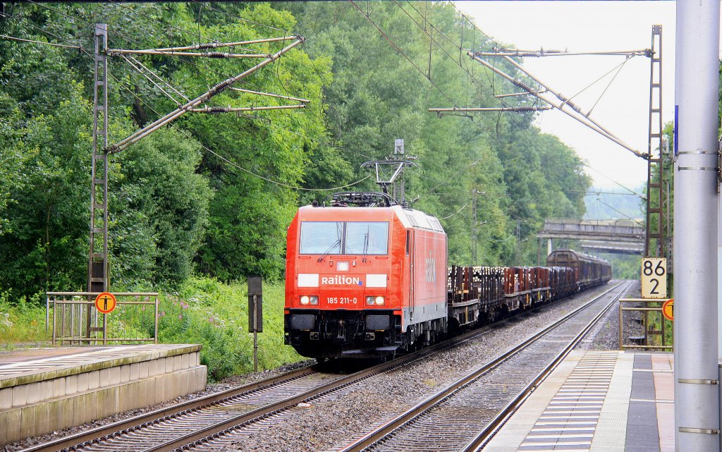 185 211-0 von Railion durchfhrt den Bahnhof Salmtal mit einem gemischten Gterzug aus Richtung Trier-Ehrang und fhrt in Richtung Koblenz bei Regenwetter am 12.7.2012.