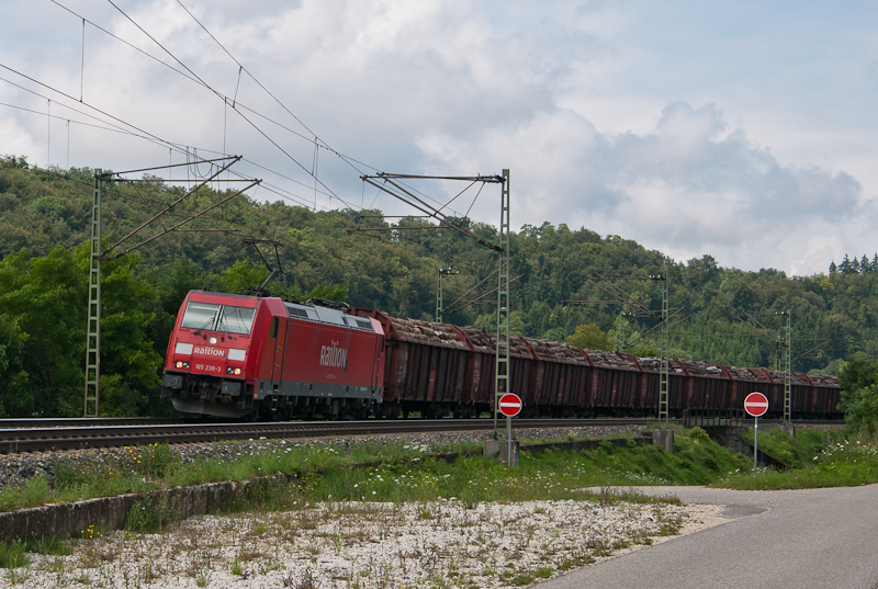 185 238-3 am 28. Juli 2011 mit einem Holzzug bei Urspring.