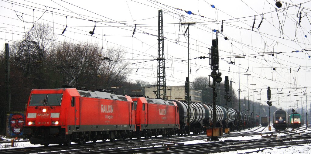 185 310-0 und 185 291-2 beide von Railion fahren mit einem langen lzug aus  Antwerpen-Petrol(B) nach Basel(CH) bei der Ausfahrt in Aachen-West und fahren in Richtung Kln im Schnee am 9.12.2012.