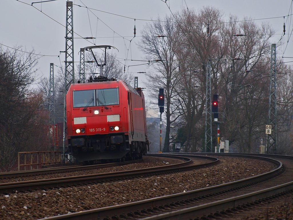 185 315-9 legt sich am 18.02.2011 von Kln kommend hinter Aachen Rothe Erde galant mit einem Containerzug am Haken in die Kurve.