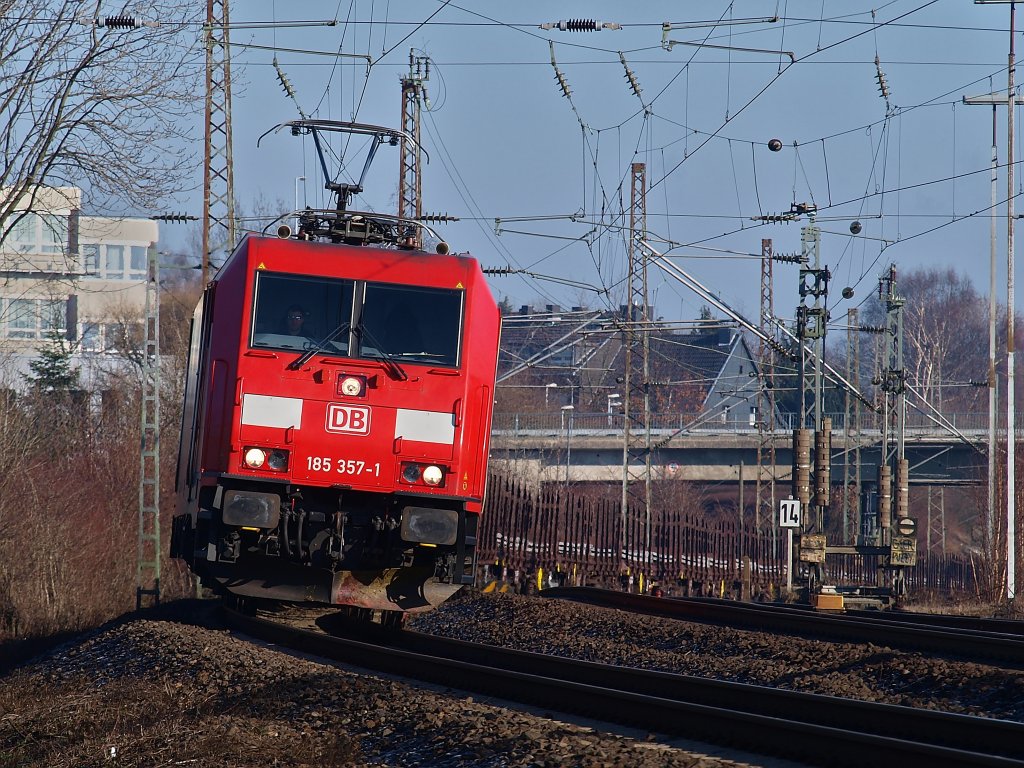 185 357-1 zieht am 29.01.2011 einen langen Zug Drehgestellflachwagen mit Rungen, die mit Stahlplatten beladen sind auf der KBS 480 bei Aachen Rothe Erde nach Aachen West.
