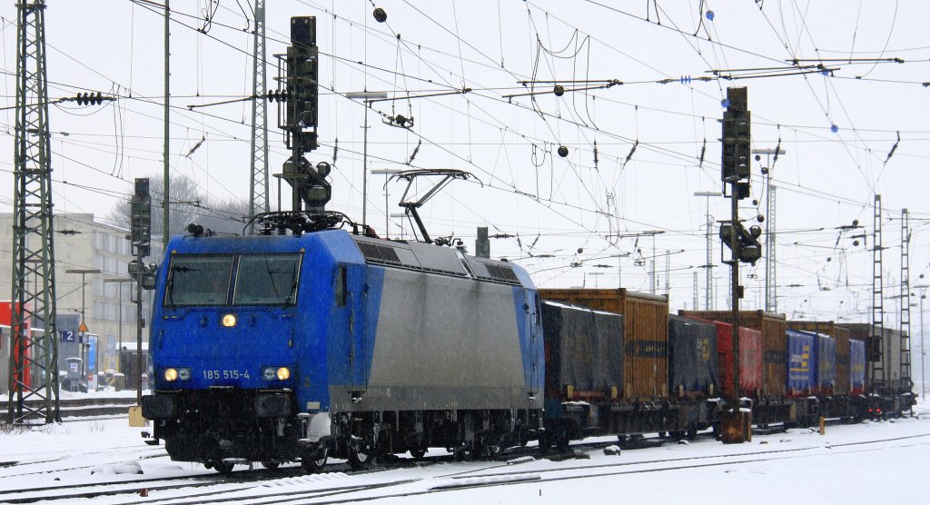 185 515-4 von Railtraxx fhrt mit einem langen Containerzug aus Bierset-Awans(B) nach Basel(CH) bei der Abfahrt aus Aachen-West und fhrt in Richtung Aachen-Hbf,Kln bei leichten Schneefall am Kalten 24.2.2013.