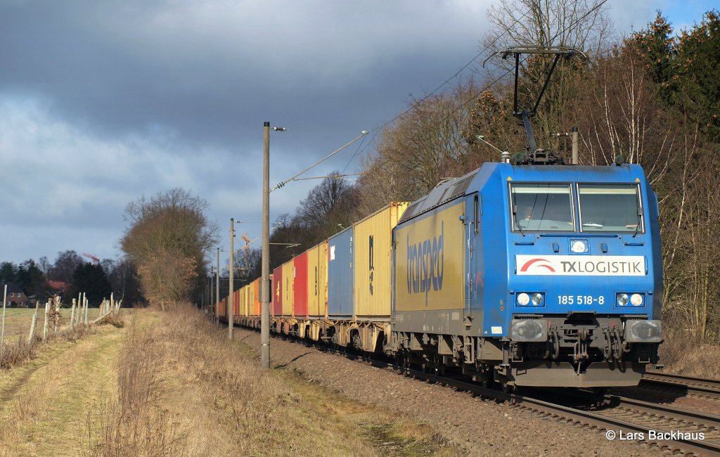 185 518-8 TX Logistik hat am 26.02.12 einen Kistenzug am Haken und passiert mit diesem Reindorf Richtung Hamburg.