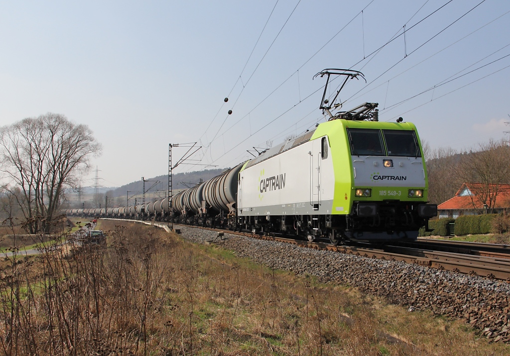 185 549-5 trgt ihr Captrain Gewand auch noch nicht so lange. Hier ist sie mit einem Kesselwagenzug in Richtung Norden unterwegs. Aufgenommen bei Mecklar am 24.03.2012.