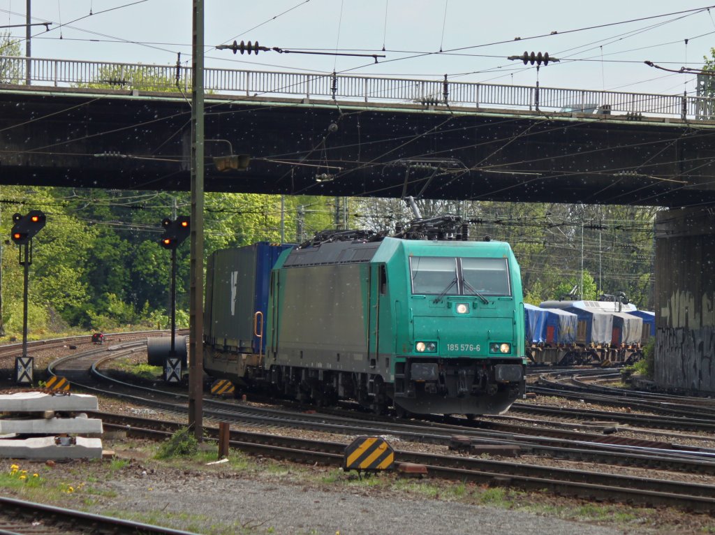 185 576-6 von Crossrail zieht am 16.04.2011 von Kln kommend einen gemischten Gterzug durch eine Wolke weier Erlensamen unter der Brcke Turmstrasse nach Aachen West.
