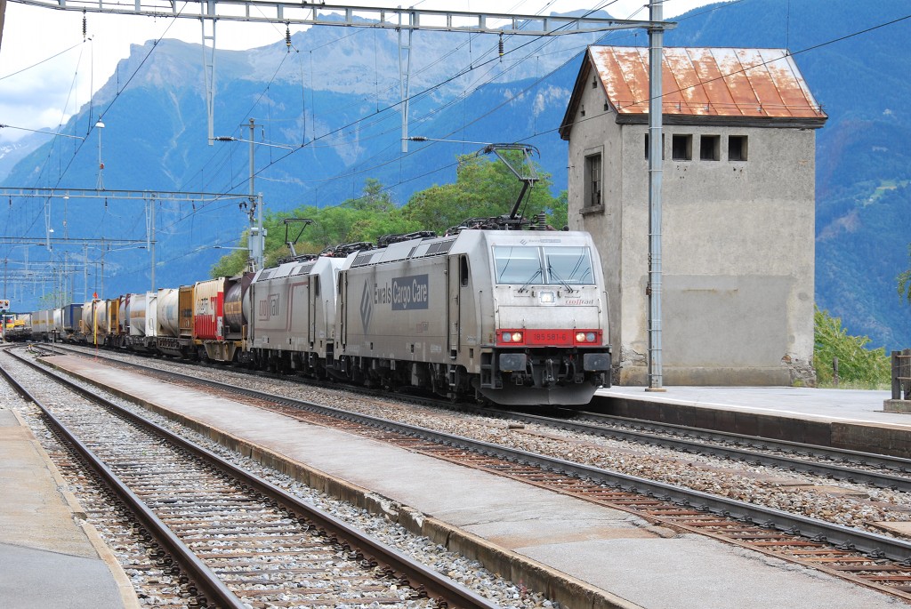 185 581-6 und eine weitere 185'er von Crossrail sind mit einem Gterzug auf der BLS-Sdrampe in Richtung Norden unterwegs, hier beim Bahnhof von Ausserberg; 26. Juli 2011.