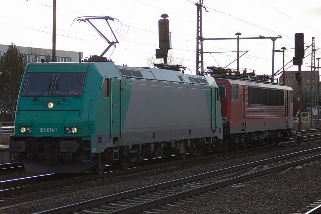 185 611-1 mit einer BR 155 (vermutlich 155 024-x) im Schlepp bei der Durchfahrt durch den Bahnhof  Berlin Schnefeld Flughafen am 15. Januar 2012 Richtung Berlin.