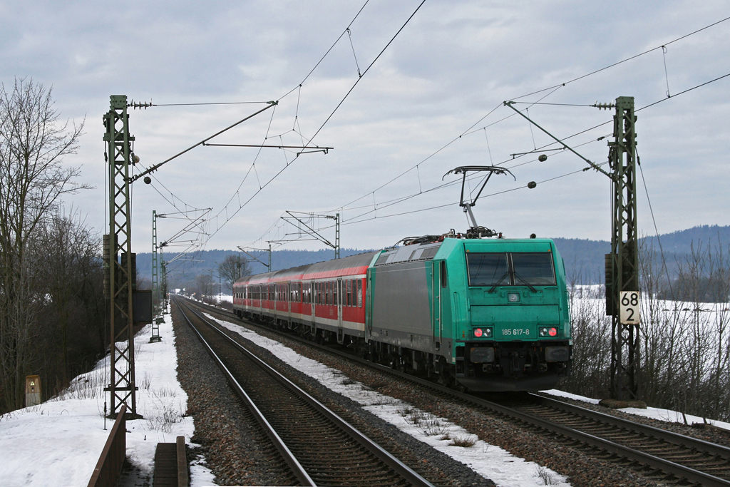 185 617 hat soeben die Haltestelle Plling verlassen und schiebt ihre S-Bahn Richtung Nrnberg. Aufgenommen am 08.01.2011. Fotostandpunkt war das Ende des Bahnsteigs in Plling, somit ffentlich zugnglich.