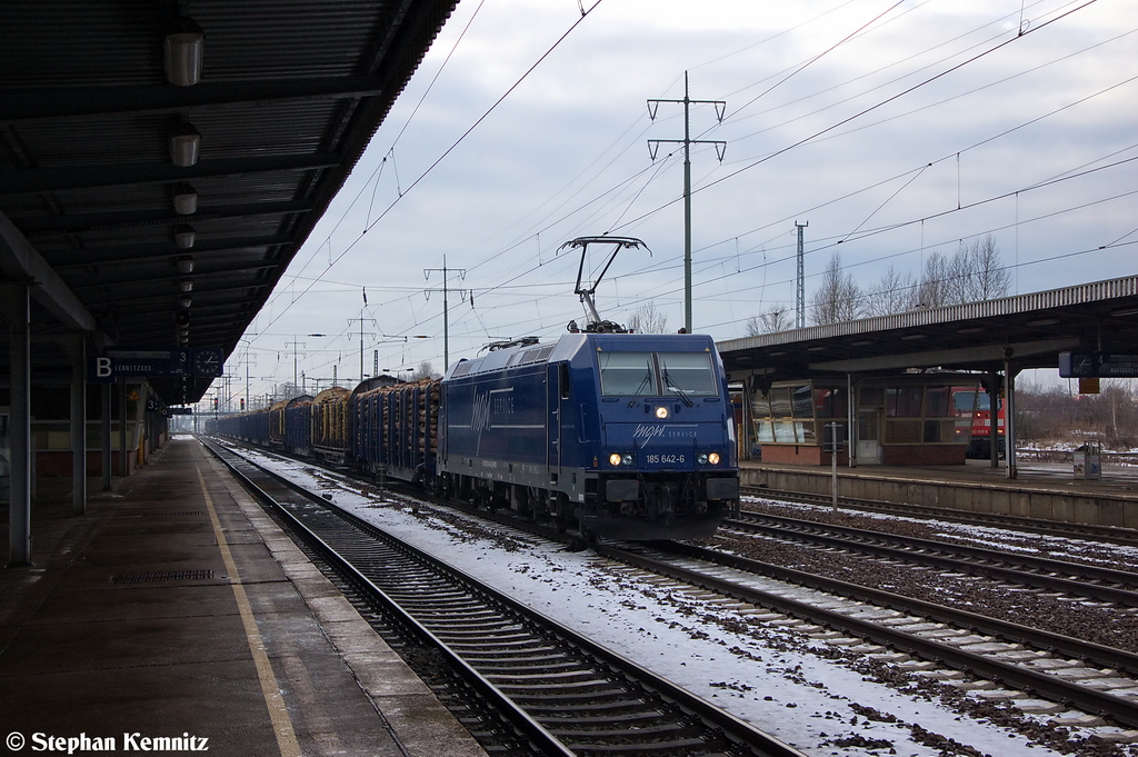 185 642-6 mgw Service GmbH & Co. KG fr HLG - Holzlogistik and Gterbahn GmbH mit einem Holzzug in Berlin-Schnefeld Flughafen und fuhr in Richtung Grnauer Kreuz weiter. 17.12.2012