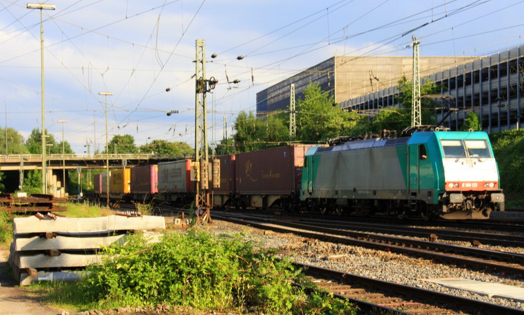 186 123 von Railtraxx kommt aus Richtung Köln,Aachen-Hbf mit einem langen KLV-Containerzug aus Frankfurt-Höchstadt nach Genk-Goederen(B) und fährt in Aachen-West ein in der Abendsonne und Gewitterwolken am Abend vom 20.6.2013.