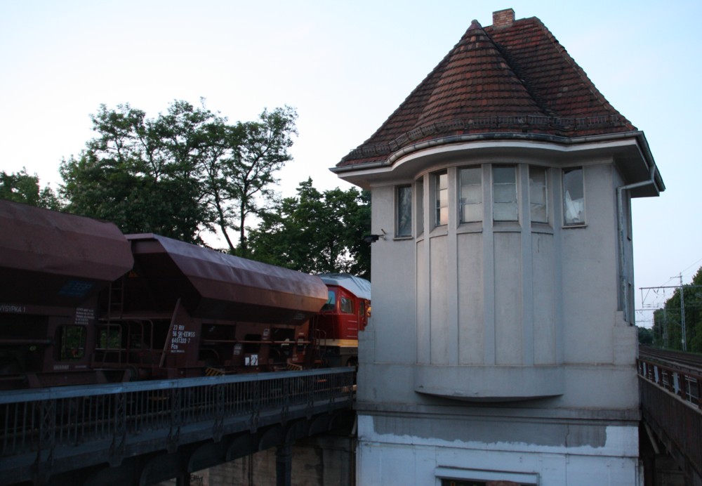 19.5.2012 Berlin-Buch. In der Abenddmmerung steht 131 012 an einem Arbeitszug mit Schotterwagen im S-Bahnhof und wartet auf Weiterfahrt ins Baugleis. Daneben das unter Denkmlaschutz stehende Stw Bwt. (ausser Betrieb seit 1983)