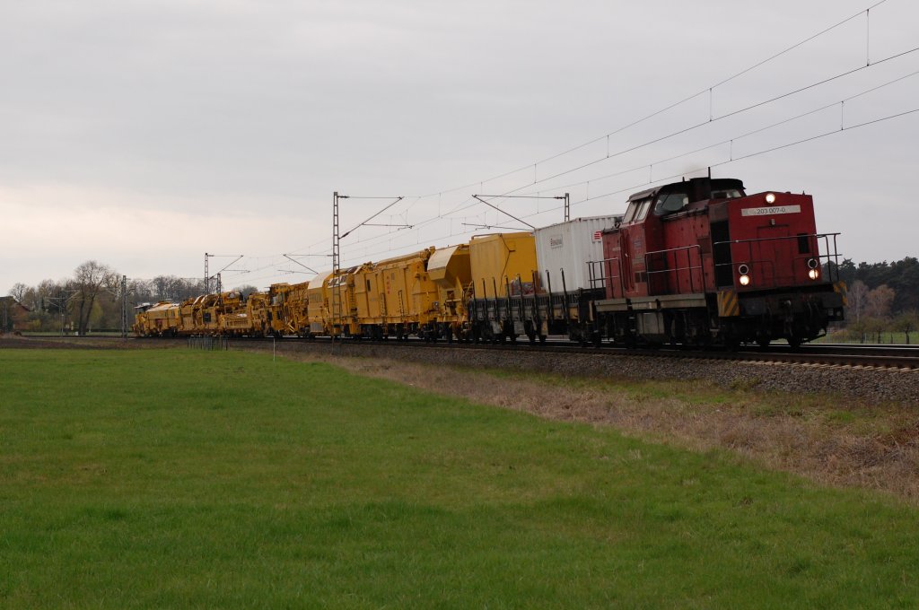 203 007-0 der Bocholter Eisenbahn mit einem langem Bauzug inkl. dem Wanne-Eickel-Express (Unterbausanierungs-Schotterbettreinigungsmaschine) hier in den Feldern zwischen Scharmede und Paderborn, 10.04.2012. 