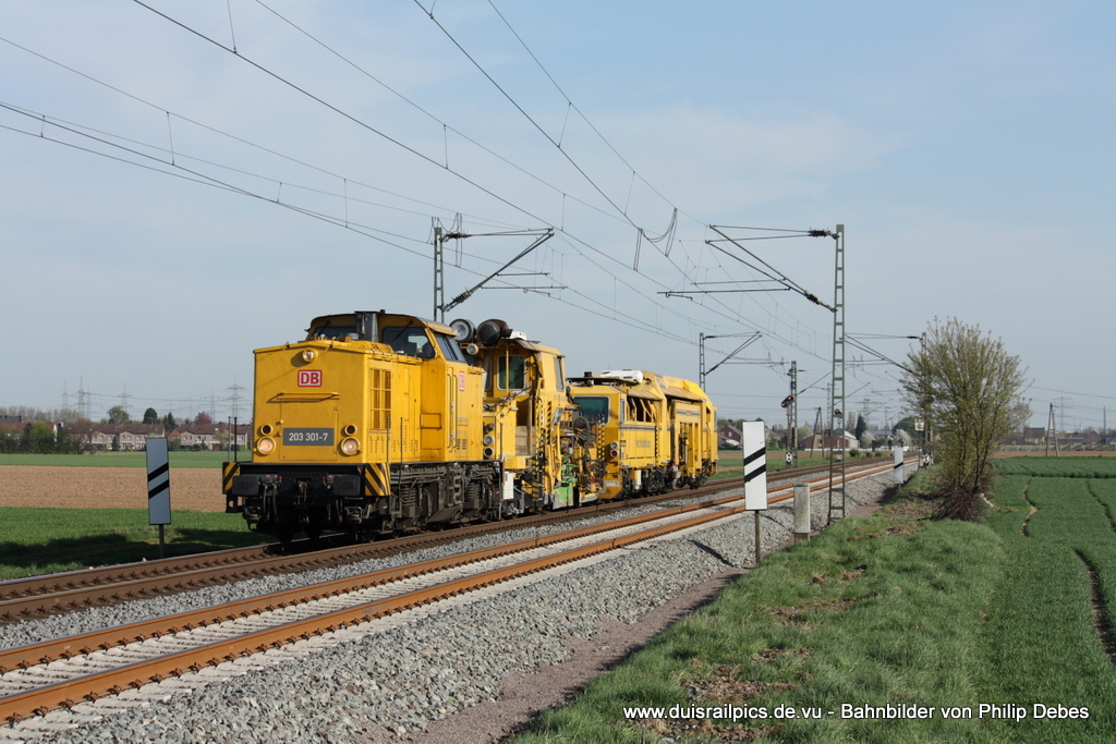 203 301-7 (DB Netz Instandhaltung) fhrt am 9. April 2011 um 17:27 Uhr mit einem Bauzug durch Neuss Allerheiligen