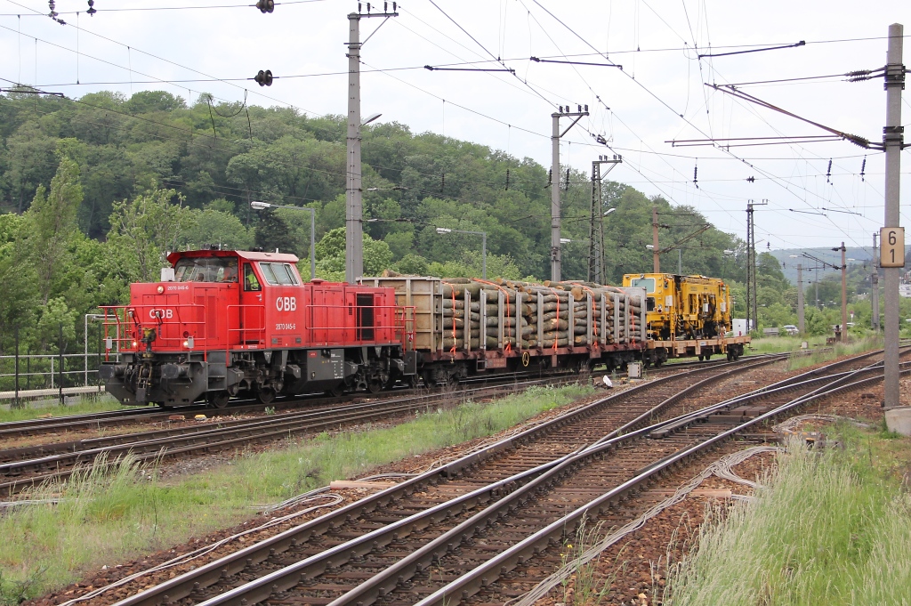 2070 045 mit einem Holzwagen und einer Schmalspur-Stopfmaschine auf der Ladeflche. Gesehen am 16.05.2013 in Wien Htteldorf.