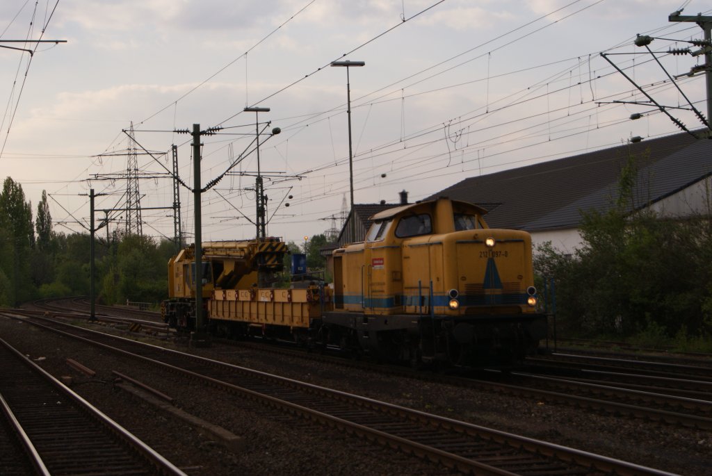 212 097-0 mit einem Baukran bei der Durchfahrt durch Dsseldorf-Eller am 17.04.2011