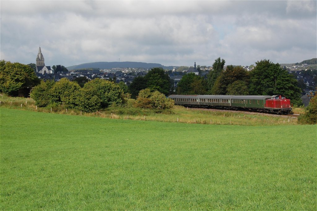 212 133 mit ihrer RB nach Korbach  auf  Bergfahrt  gen Brilon Wald, im Hintergrund die Huser vom Stdtchen Brilon, 01.09.2012.