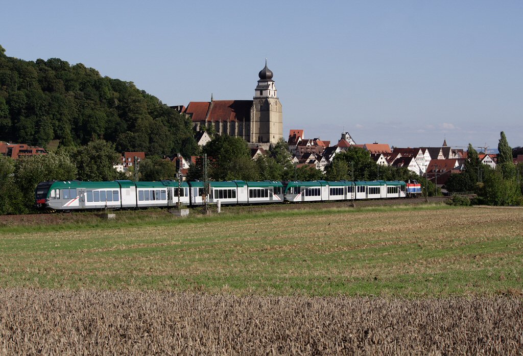212 279-4 berfhrt zwei Stadler GTW vor der Kulisse der Stiftskirche Herrenberg, 10.08.11
