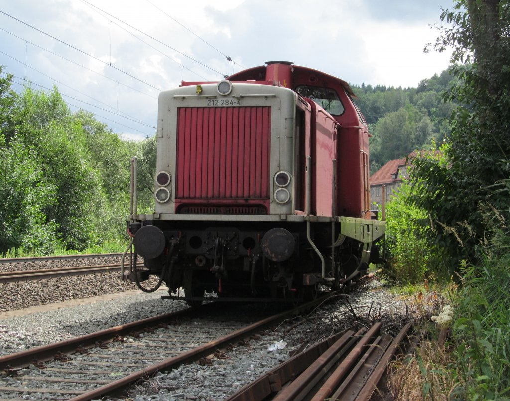 212 284-4 der BayernBahn steht am 15. Juli 2012 im Anschlussgleis des Kronacher Minerallwerkes abgestellt.