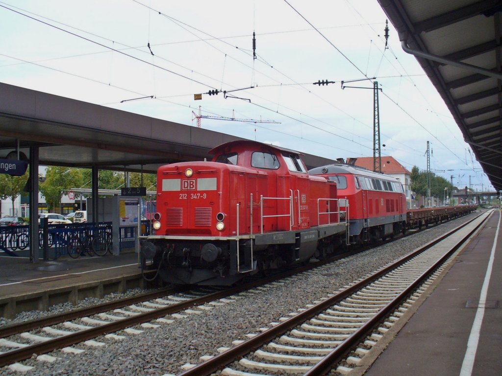 212 347-9 und 218 139-4 ziehen einen Flachwagenzug am06.10.2011 durch Schwetzingen 

