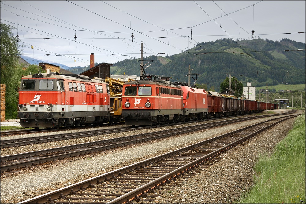 2143 062 steht mit einem Bauzug im Bahnhof Thalheim-Pls, whrend im Vordergrund ein Gterzug mit der Vorspannlok 1042 041 vorbeifhrt.  31.05.2010
