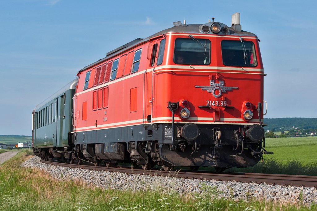 2143.35 ist mit dem EZ 7399 von Ernstbrunn nach Wien Sdbahnhof (Ostseite) unterwegs. Die Aufnahme enstand am 29.05.2011 zwischen Harmannsdorf-Rckersdorf und Stetten Fossilienwelt.