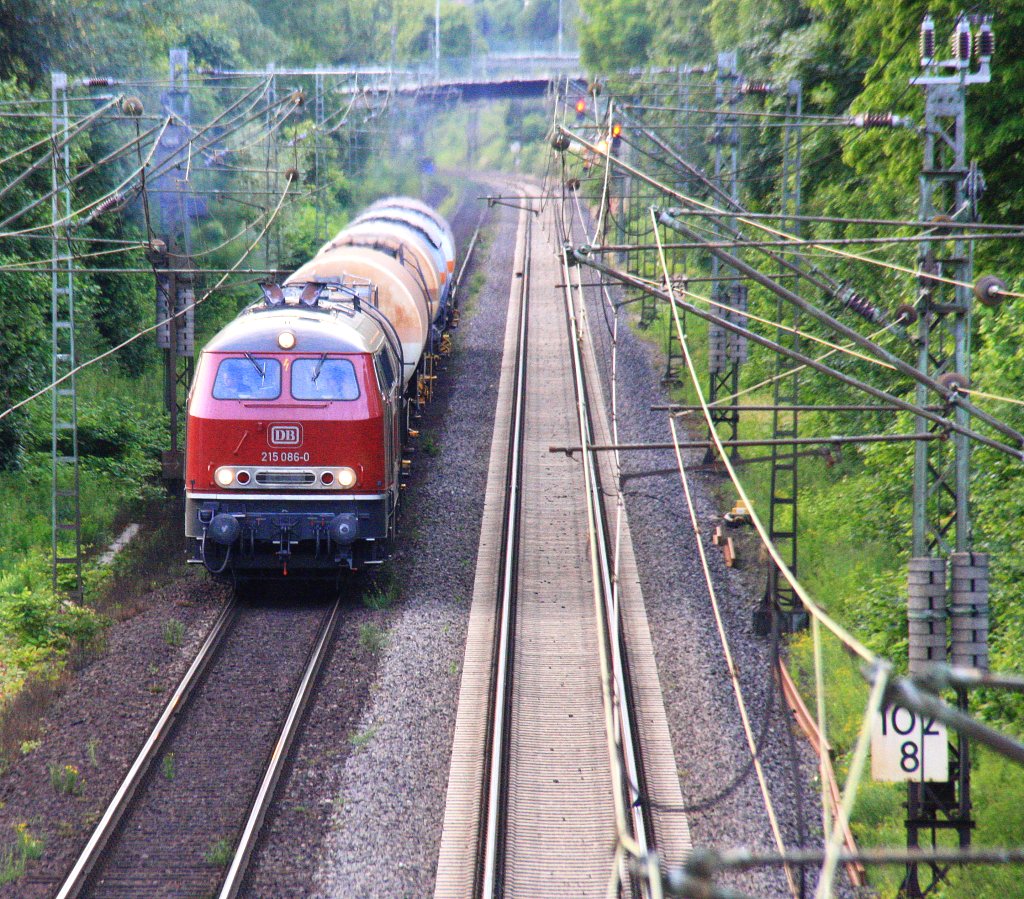 215 086-0 DB kommt mit viel Qualm aus Richtung Kln mit einem kurzen Kesselzug aus Kln-Gremberg nach Linz am Rhein und fhrt in Richtung Koblenz auf der Rechten Rheinstrecke (KBS 465) bei Bad-Honnef am Rhein in der Abendstimmung am Abend vom 25.6.2013. 