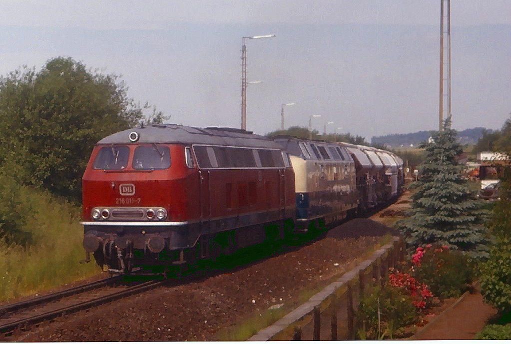 216 011 und 221 124 bringen einen Leerwagenzug durchs Angertal nach Rohdenhaus, Aufnahme bei der Ausfahrt aus Flandersbach, 12.06.1983.