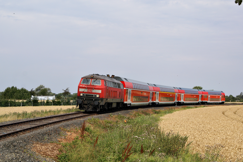 218 407-5 fhrt am 31.07.2010, dem Tag der Wiedererffnung, mit einem RE nach Hamburg in das Gleisdreieck von Burg(Fehmarn) ein und erreicht in Krze den neu errichteten Bahnsteig. 