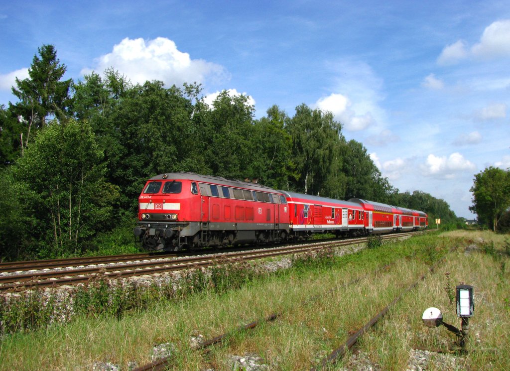 218 443 zieht den IRE 4209 (Ulm Hbf-Lindau Hbf) mit Fahrradtransportwagen bei Laupheim gegen Sden. Im Vordergrund die nicht mehr in Betrieb befindlichen Gleise des Riss-Kieswerks. (11.September 2010)