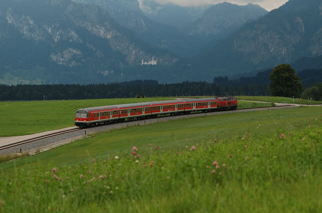 218 464-8 mit RE 32617, Fssen - Mnchen Hbf zwischen Fssen & Weizern-Hopferau. Im Hintergrund ist das Schloss Neuschwanstein zu erkennen. August 2010