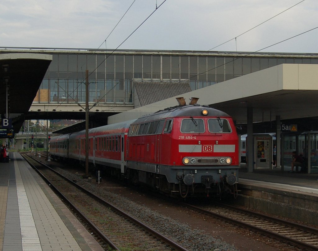 218 484-4 fhrt mit Lr 28675, Tauberbischofsheim - Ludwigshafen(rhein), gerade in Heidelberg Hbf von Gleis 3 ab, nachdem die S2 nach Kaiserslautern Hbf Gleis 2 verlassen hat. Heute morgen ging die Fahrt als Lr 70465 von Ludwigshafen(rhein) nach Lahr um von dort die Fahrgste von Lahr nach Tauberbischofsheim zur Auftaktveranstaltung der  SWR4 Tour de Lndle  zu bringen. Als ich von der Uni zurck nach Hause fahren wollte, stand der Zug noch in Heidelberg. Links ist noch das abgerundete Bahnsteigdach der Bahnsteige 2+3, rechts das gewhnliche eckige Bahnsteigdach der Bahnsteige 4+5 zu sehen. Nur das Wetter hatte sich dem Grau des Bahnhofes um diese Zeit schon angepasst. 27.07.2012
