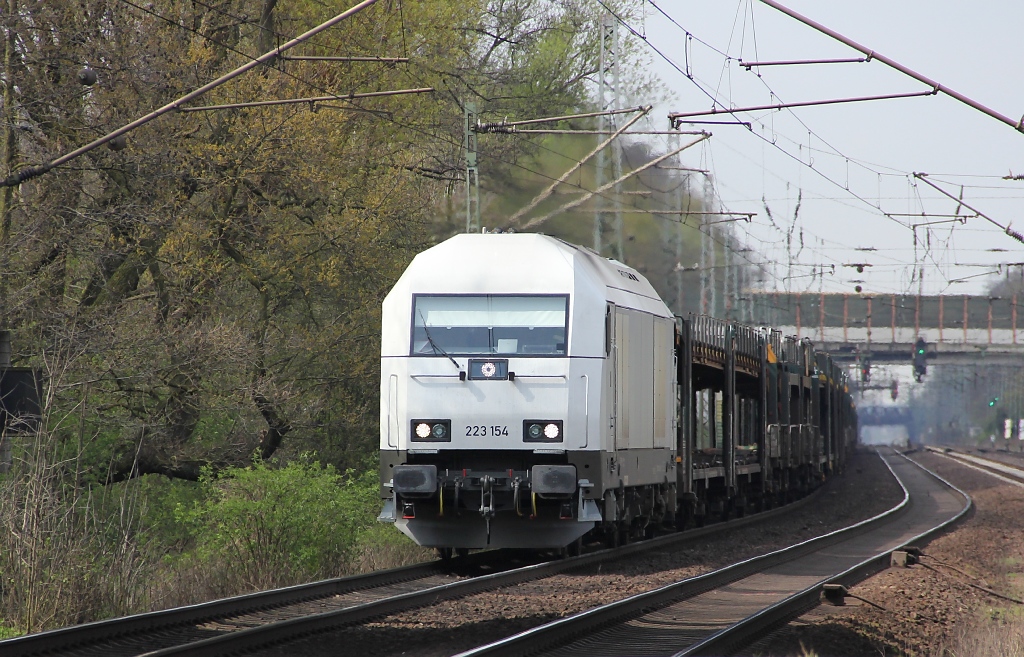 223 154 der PCT bringt einen leeren Autotransportzug in Richtung Seelze. Aufgenommen am 17.04.2012 in Dedensen-Gmmer.
