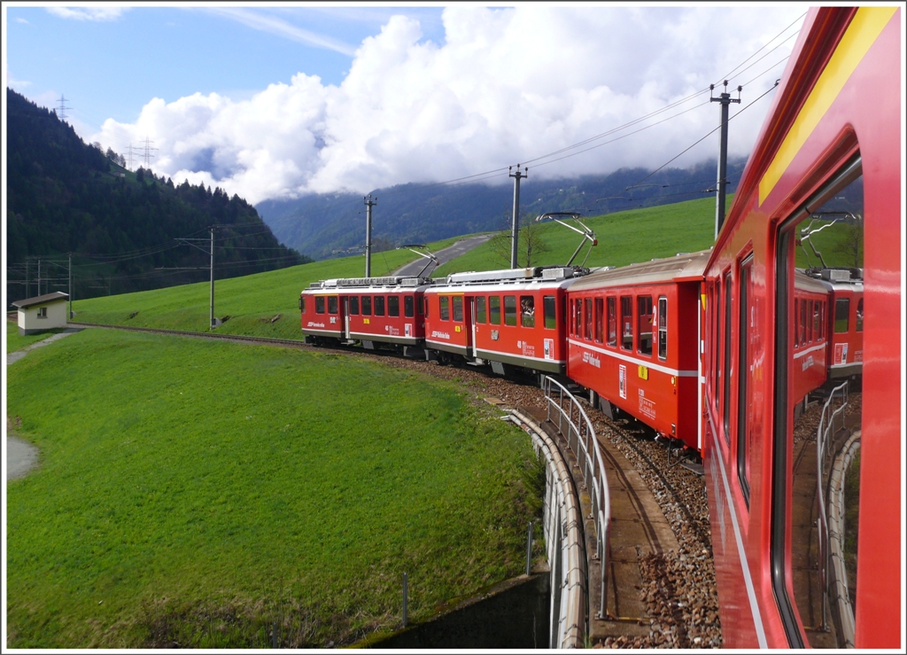 23 Minuten spter bei Privilasco prsentiert sich die Landschaft komplett anders. R1613 mit ABe 4/4 II 45 und 48 fhrt durch saftige Wiesen Richtung Poschiavo. Die Wolken im Hintergrund markieren so ungefhr die Schneefallgrenze. (08.05.2010)