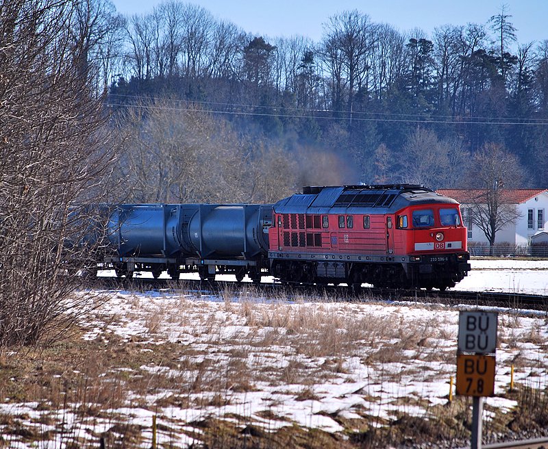 233 596 legt sich mit einem Mllzug am 25.2.2010 von Alttting kommend in die langgezogene Einfahrtskurve kurz vor Tling. 