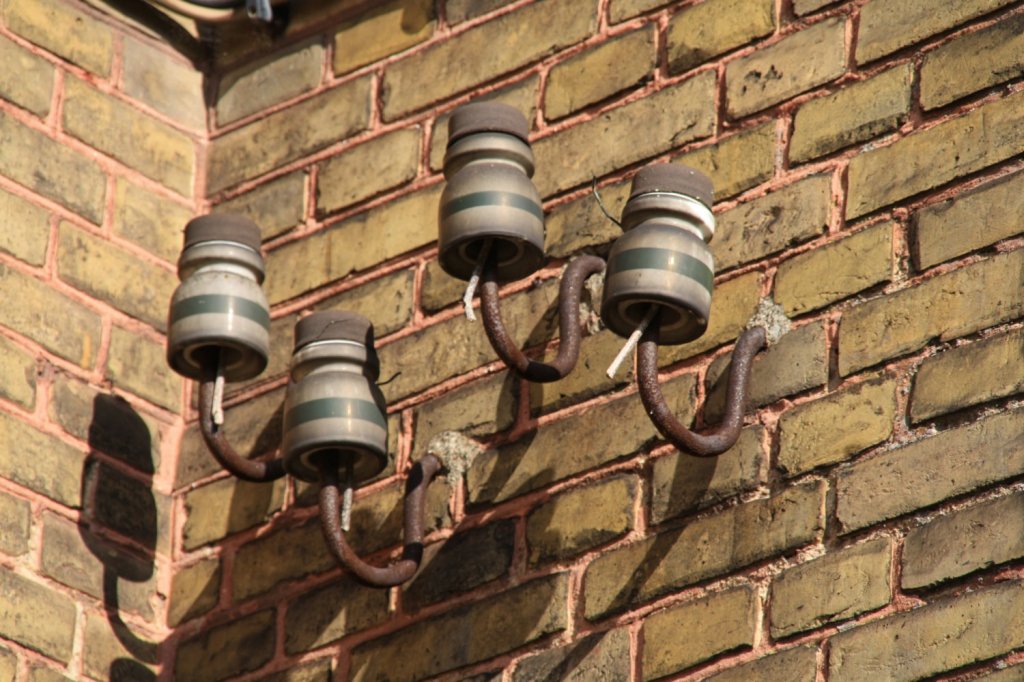 24.7.2011 Wilmersdorf, Strecke Angermnde - Stralsund. Isolatoren mit Bakelitkappe am Empfangsgebude.