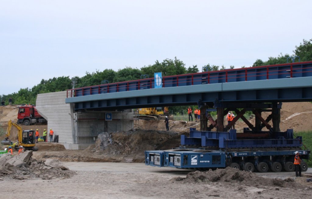 27.5.2012 Neue Br�cke der NEB �ber die A10. Noch ein paar cm und sie ist drin. Trotz schlechter Lichtverh�ltnisse noch gut erkennbar der SPMT  (Self Propelled Modular Trailer) der Sarens Group.