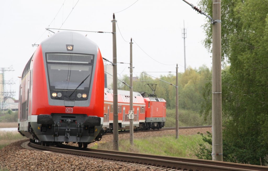 29.4.2012 bei Angermnde. RE3 nach Stralsund legt sich in die Kurve kurz vor dem berwerfungsbauwerk ber die Stettiner Eisenbahn. Geschoben hat 112 182.