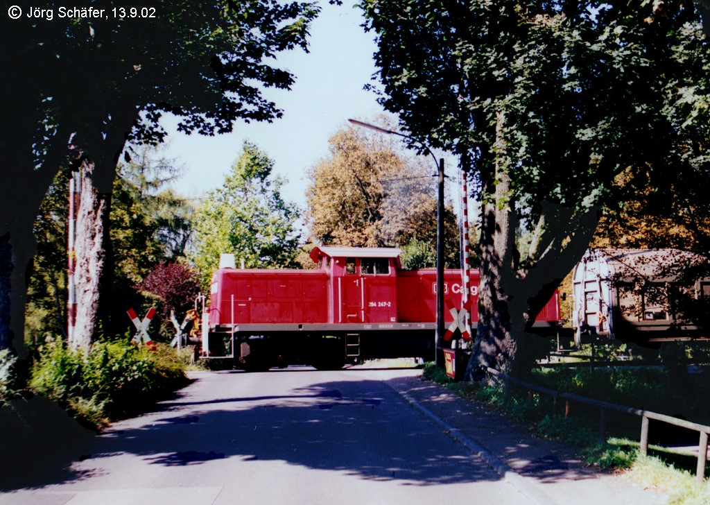298 247 auf dem nchsten Bahnbergang in Rothenburg - die handbedienten Schranken blieben oben. Seit 1971 fahren auf der ehemals bis Dombhl fhrenden Strecke nur noch Gterzge. (Blick nach Westen am 13.9.02)