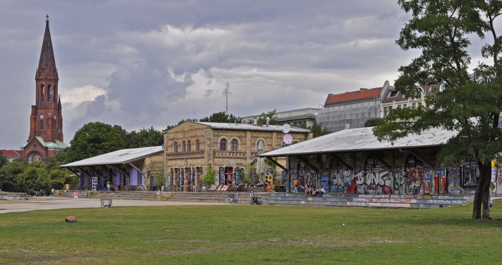 30.07.2013, Berlin-Kreuzberg, ehem. Grlitzer Bahn. Letzte vorhandene Bauten des ehem. Grlitzer Bf's: restaurierte Gterschuppen, heute fr Restaurants und Kultur genutzt. Das gesamte Bahnhofsgelnde wurde zum Grlitzer Park (im Kiez als  Grli  bezeichnet) umgestaltet.