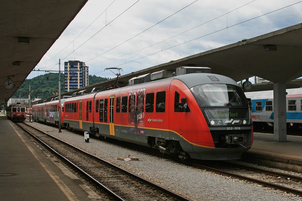 312 018 wartet zusammen mit einem dreiteiligen Desiro auf die Abfahrt, aufgenommen am 01.06.2010 in Ljubljana.