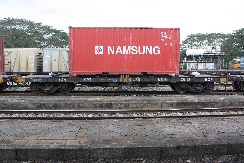 บ.ท.ต. 28118 (บทต = B.C.F./Bogie Container Flat Wagon) am 06.Jänner 2013 im Bf. Thung Song Junction. Der Wagen wurde 1957 von Fuji Car Mrg.Co.Ltd. in Osaka/Japan als B.F.W.(Bogie Flat Wagon) gebaut und später von den SRT zum B.C.F.(Bogie Container Flat Wagon) umgebaut. 

