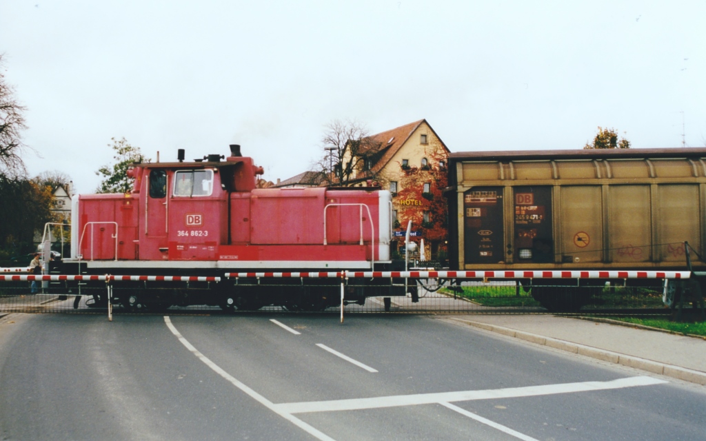 364 862 schiebt die Gterwagen fr den Werksanschluss des AEG-Werks in Rothenburg ob der Tauber am 18.9.02 ber den Bahnbergang der Bundesstrae B 25. Unmittelbar links davon liegt die sdlichste Weiche des Bahnhofs.