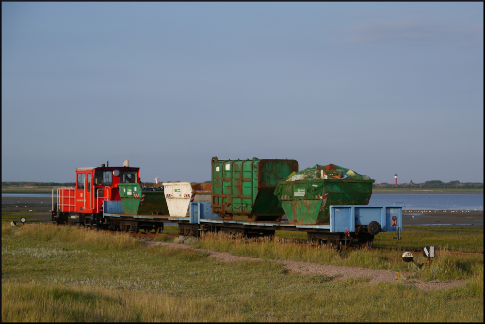 399 108 schiebt einen M�llzug von der M�lldeponie im Wangerooger Dorf in den Hafen, wo die Abfall-Container mit einem Schiff ans Festland transportiert werden. Durch die geringe H�chstgeschwindigkeit von nur 20 km/h k�nnen die Wagen auch die ganze Strecke geschoben werden und die Container m�ssen nicht extra gesichert werden. (28.08.2012)