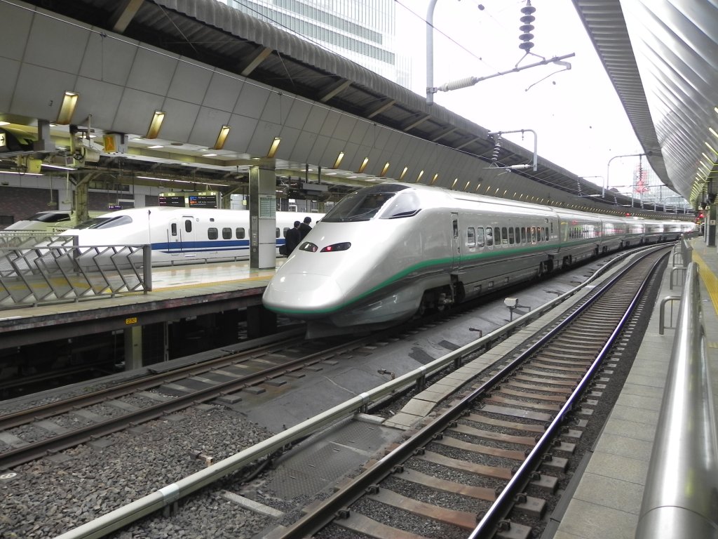 400 Series Shinkansen als Zug  Tsubasa  ( つばさ  -  Flgel ) verkehrend auf der Strecke zwischen Tokyo und Shinjō (Yamagata Shinkansen) vor der Abfahrt in JR Tokio. Im Hintergrund (von vorne nach hinten) ein 700er und ein 300er Shinkansen nach der Ankunft aus Hakata bzw. Shin-Osaka.