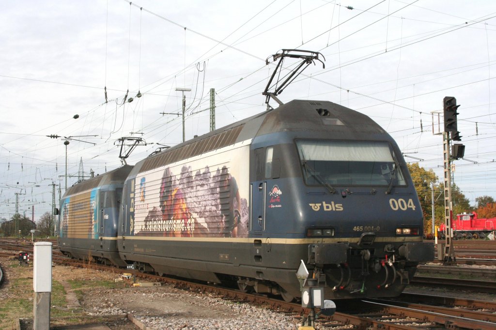465 004 am 24.10.09 in Basel Bad. Bf. Eilgut am Abstellplatz der BLS. 
Die Walliser Werbelok rangiert zusammen mit der GoldenPass Werbelok.