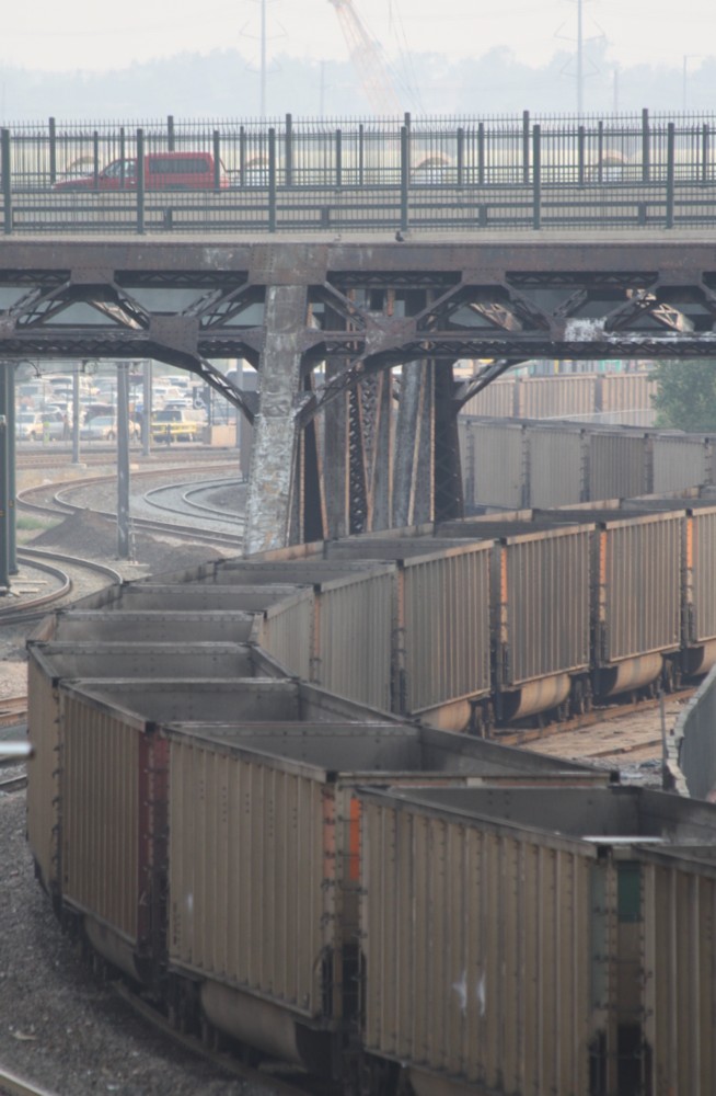4.7.2012 Denver, CO. Ein Kohle oder Eisenerzzug mit je 2 BNSF Loks an der Spitze / am Schluss schlngelt sich durch die Stadt.