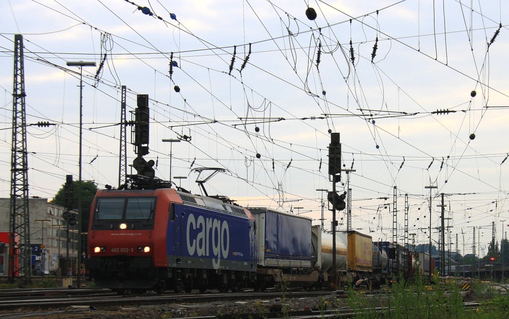 482 002-3 von der SBB Cargo fhrt mit einem Containerzug aus Antwerpen-Oorderen(B) nach Gallarate(I) bei der Ausfahrt von Aachen-West und fhrt in Richtung Aachen-Hbf,Kln in der Abendsonne und Wolken am Abend vom  26.6.2013.