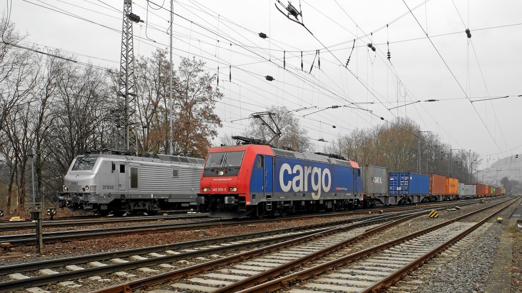 482 039-5 der SBBCargo am 27.02.2012 mit einem Containerzug an der Nordeinfahrt des Heilbronner Bahnhofs die franzsische Akiem 37032, die dort abgestellt ist, passierend.
