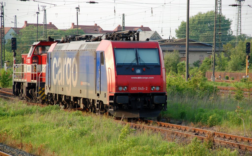 482 045 steht zusammen mit einer AKN-Maschine am 29.05.10 in Merseburg. Fotografiert aus dem fahrenden Zug.
