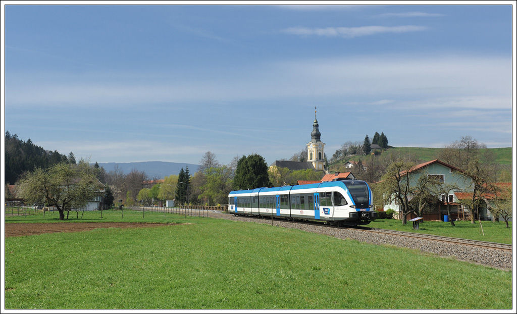 5063 008 am 17.4.2012 als S6 (R 4370) von Wies �ber Hengsberg nach Graz bei der Ausfahrt aus der Haltestelle Wies-Markt mit Blick auf die dortige Pfarrkirche.